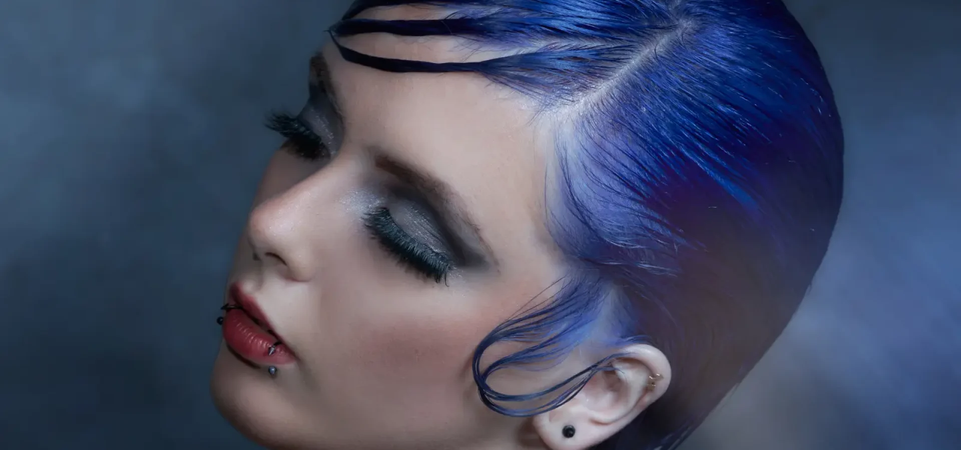 PRISM by William and Bianca Gray featuring a sleek electric blue pixie cut with sculpted texture and futuristic styling.