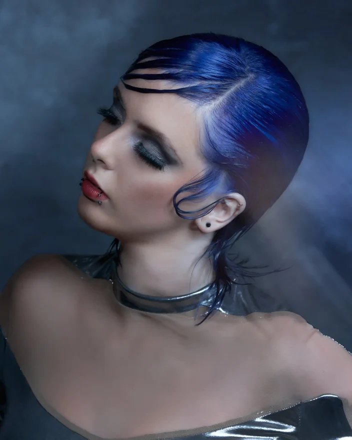 PRISM by William and Bianca Gray featuring a sleek electric blue pixie cut with sculpted texture and futuristic styling.