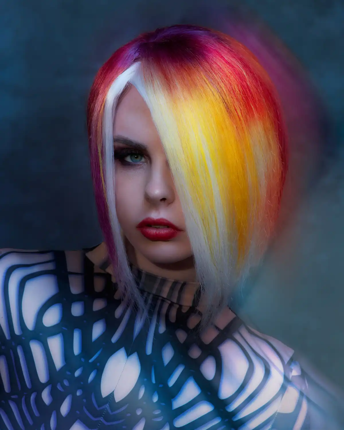 PRISM by William and Bianca Gray featuring a vibrant rainbow-coloured bob with bold geometric styling and vivid yellow, red and purple tones.