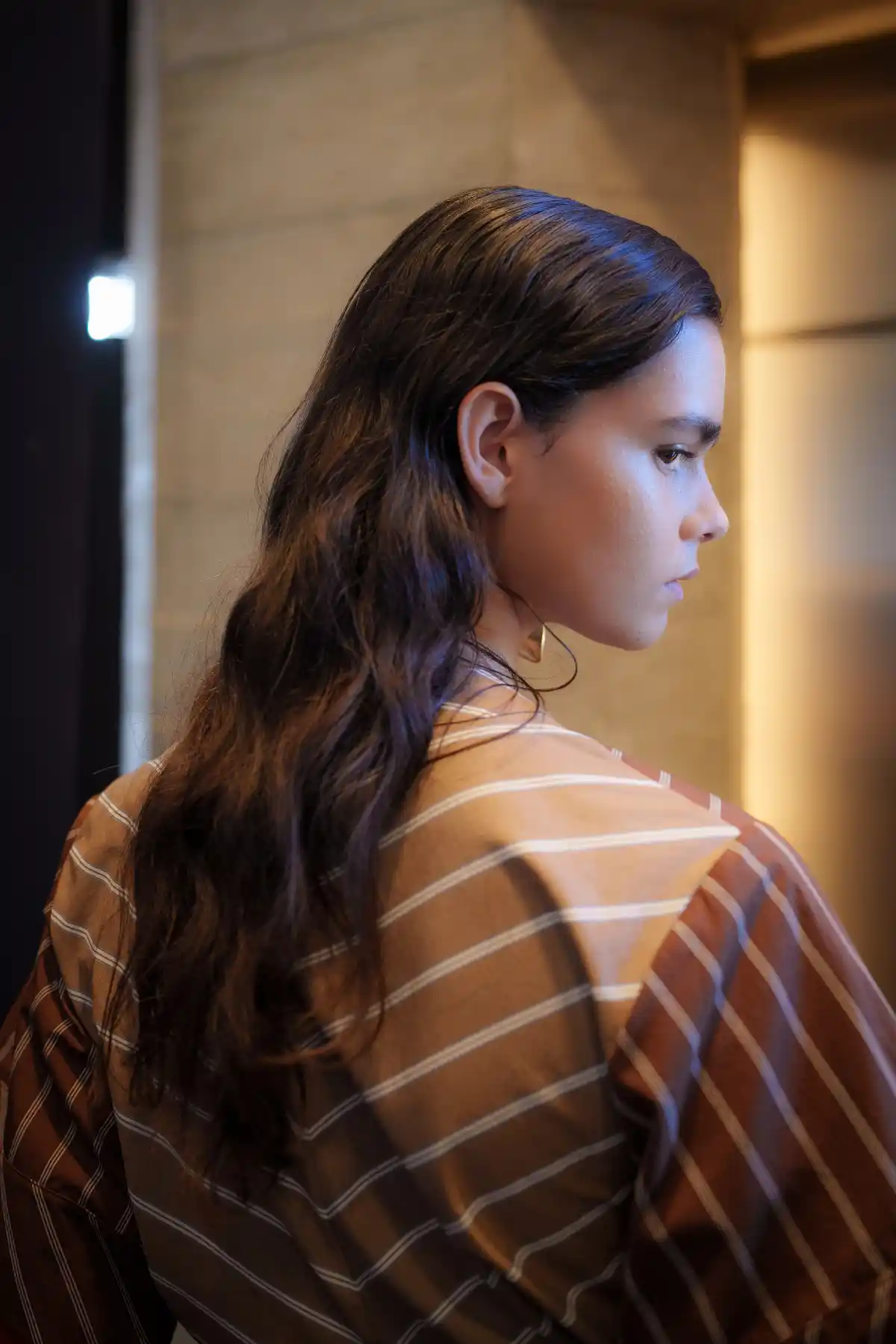 Model with long brown hair side on at ROKSANDA SS27 LFW