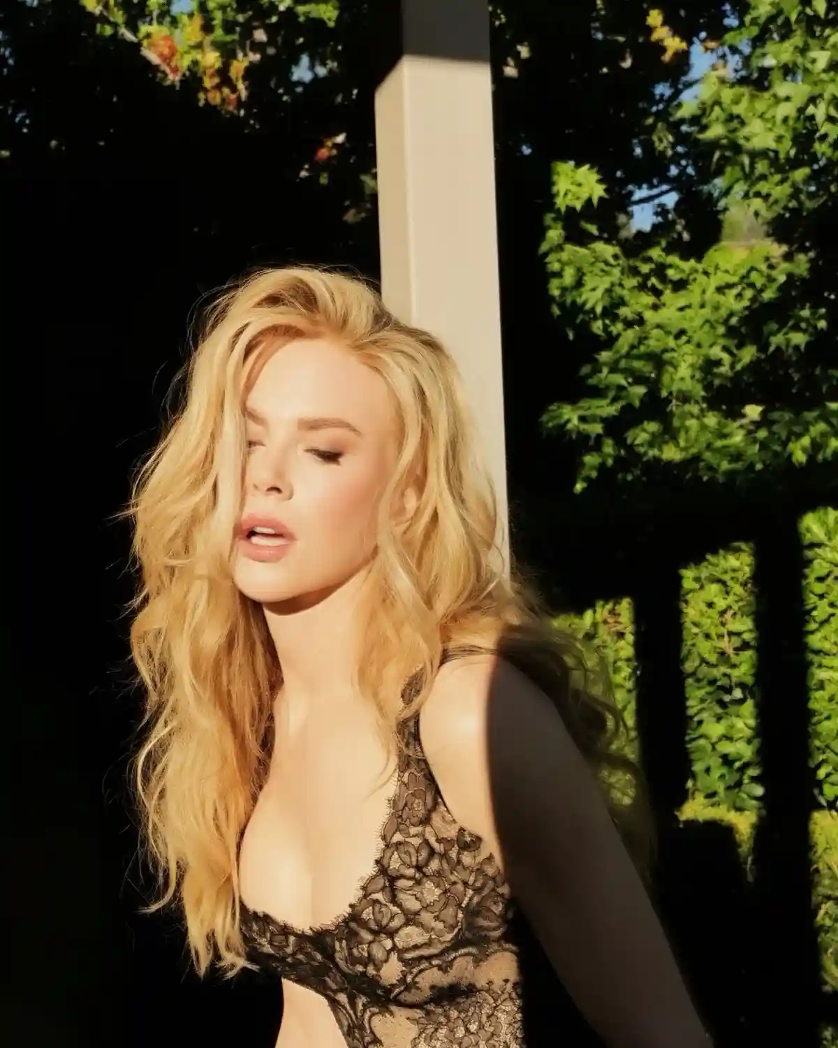 Nicole Kidman with wavy blonde long hair in a garden.