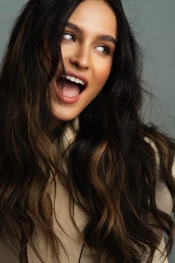 Model with brunette hair highlighting winter hair care.