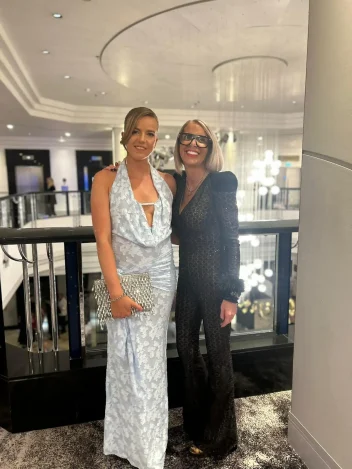 Marlene Lamont stands next to Senior Stylist Nicola an event.