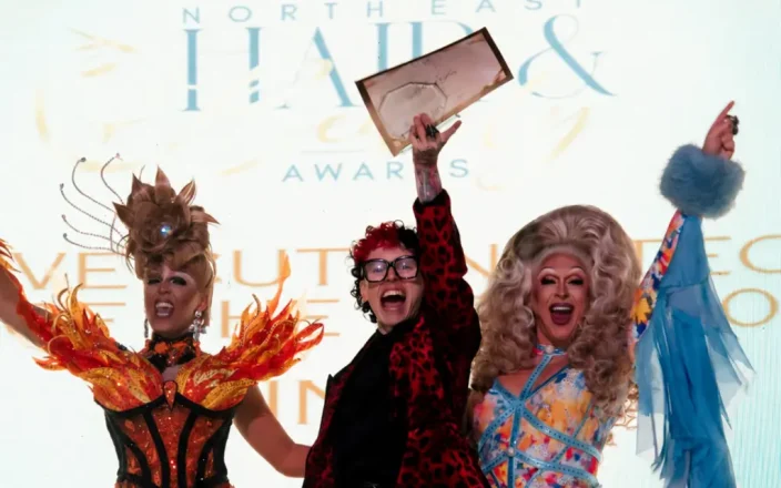 OSMO Ambassador Jude Taylor NE Hair & Beauty Awards Winner on the stage getting an award.