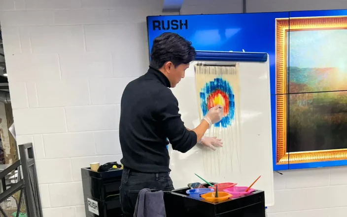 Hairdresser demonstrating colour techniques at an exhibition stand.