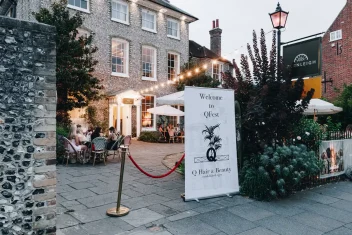 A sign advertising the Q Fest at the entrance of the salon.