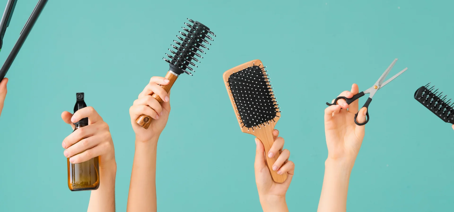 Many hands holding hair tools.