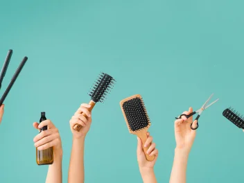 Many hands holding hair tools.