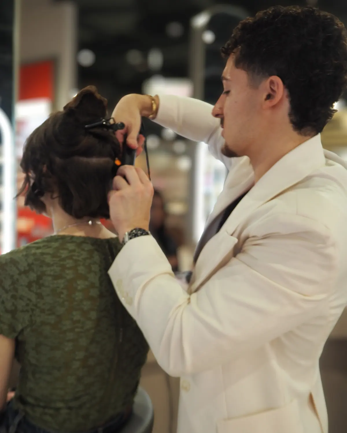Hairdresser styles a model's hair.