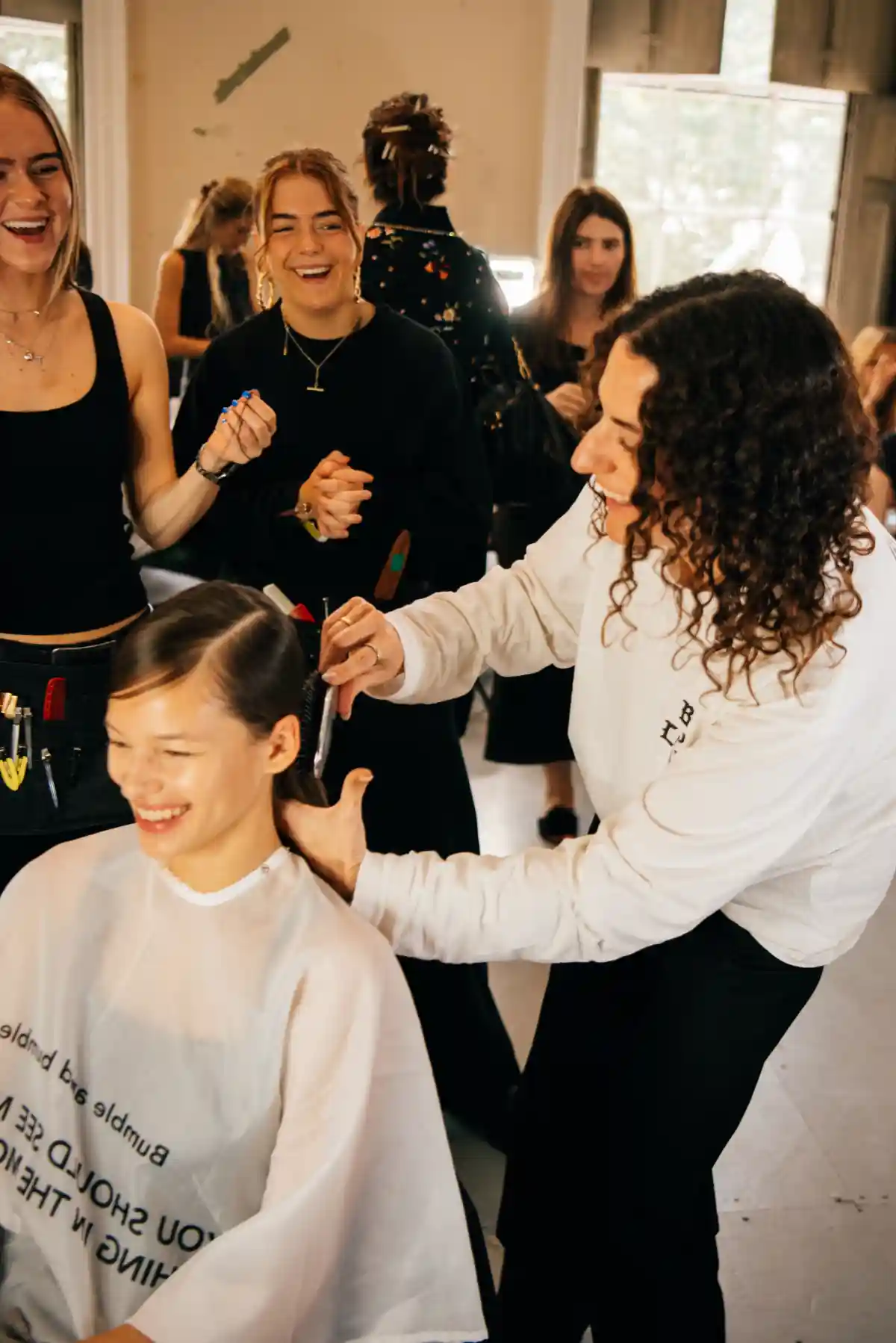 Hairdresser does a model's hair backstage at LFW TOGA with Bumble and bumble.