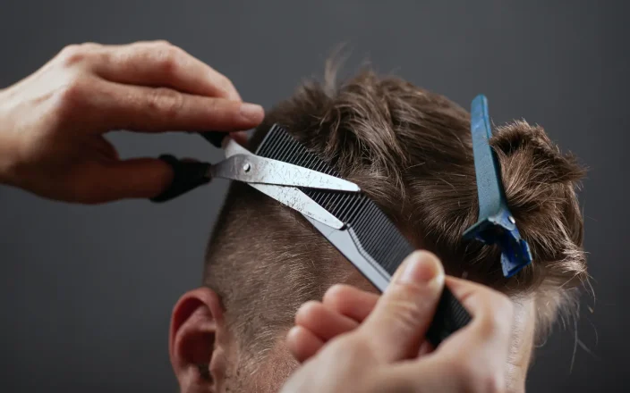 Close-up of a Barber trimming a client's hair.