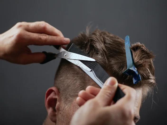 Close-up of a Barber trimming a client's hair.