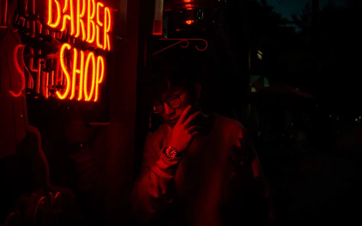A neon Barber Shop sign in a window.