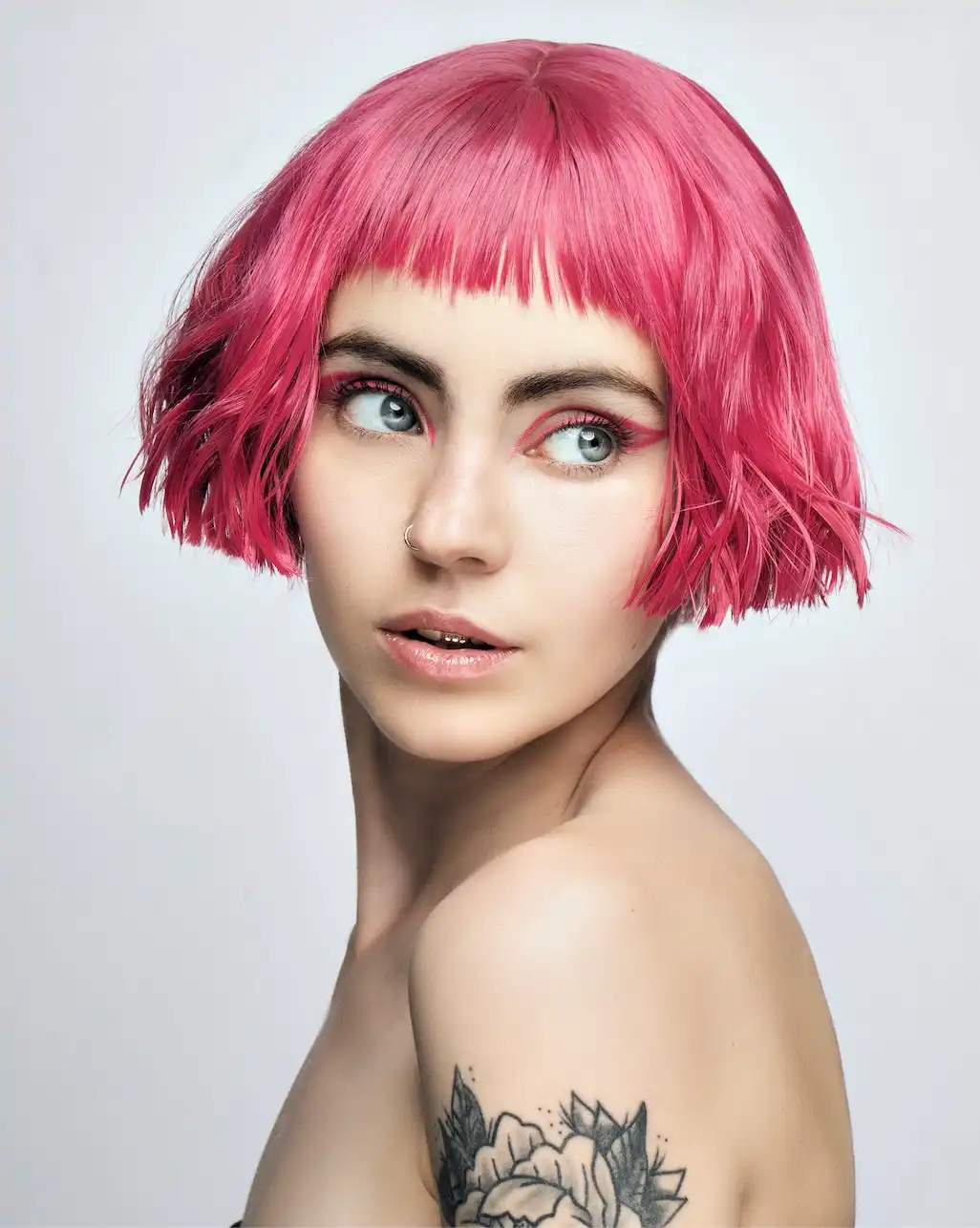 Model with cotton-candy pink hair in a contemporary micro bob.