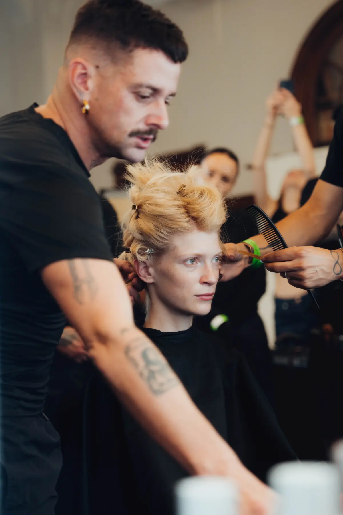 Stylist does a models hair backstage at PFW SS27 Vivienne Westwood.