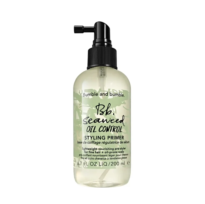 A clear pump bottle with a green tinge with branded Bumble and bumble copy.