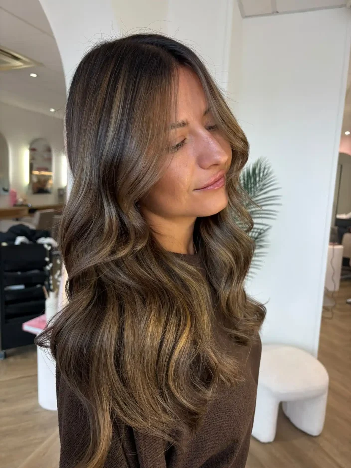 Model with hair combining highlights and lowlights to create balanced dimension throughout the hair.