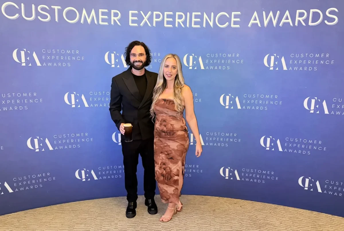 Phorest staff in front of a blue customer experience board at an event.
