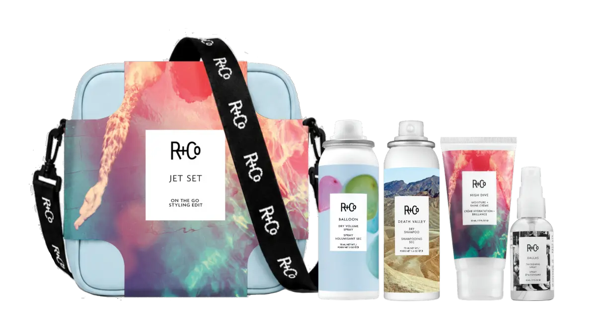 Bottles of High Dive Moisture + Shine Crème, Death Valley Dry Shampoo, Balloon Dry Volume Spray, and Dallas Thickening Spray next to a gift bag.