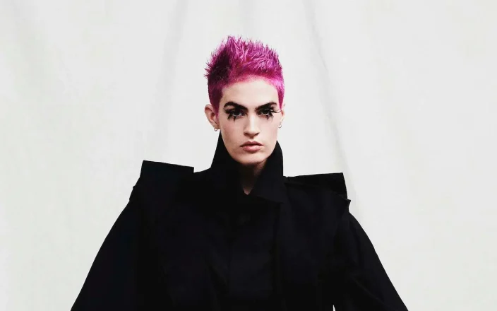 Model with vibrant pink hair that creates a bold statement, while textured spikes add a punk-inspired edge.