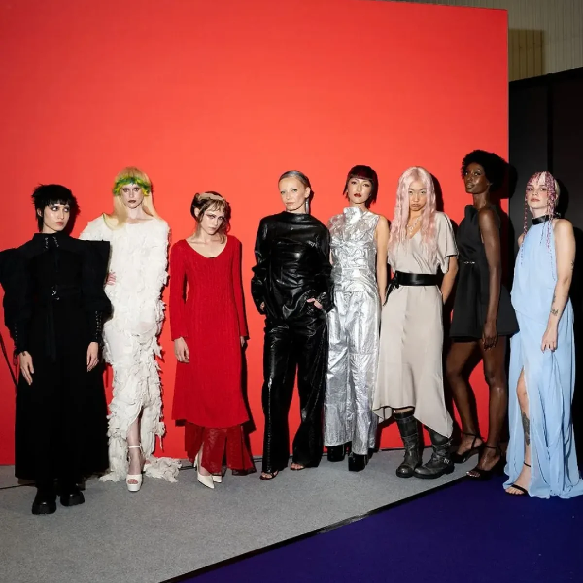 Hair models stand by an orange wall at Salon International.
