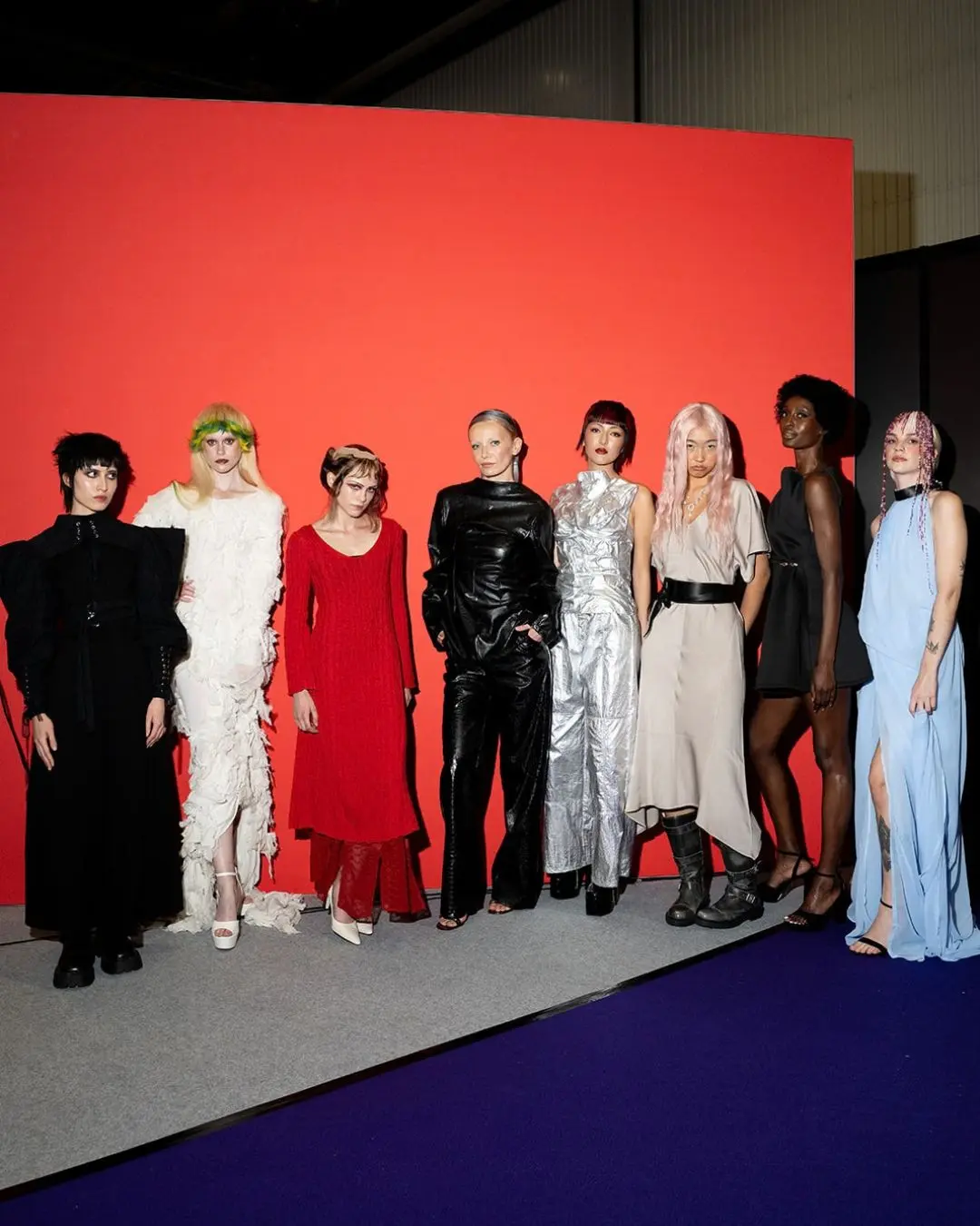 Hair models stand by an orange wall at Salon International.