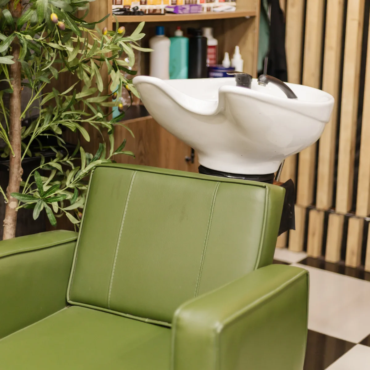 green salon chair by plant in a salon