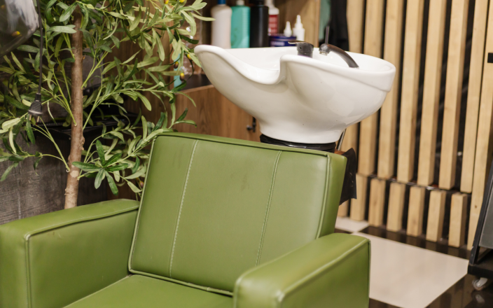 green salon chair by plant in a salon