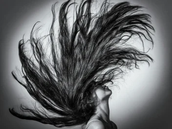 Black and white image of a model with long hair.