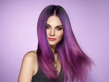 A model with purple hair on a purple background