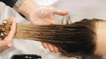 a hand washes long hair at a salon basin.
